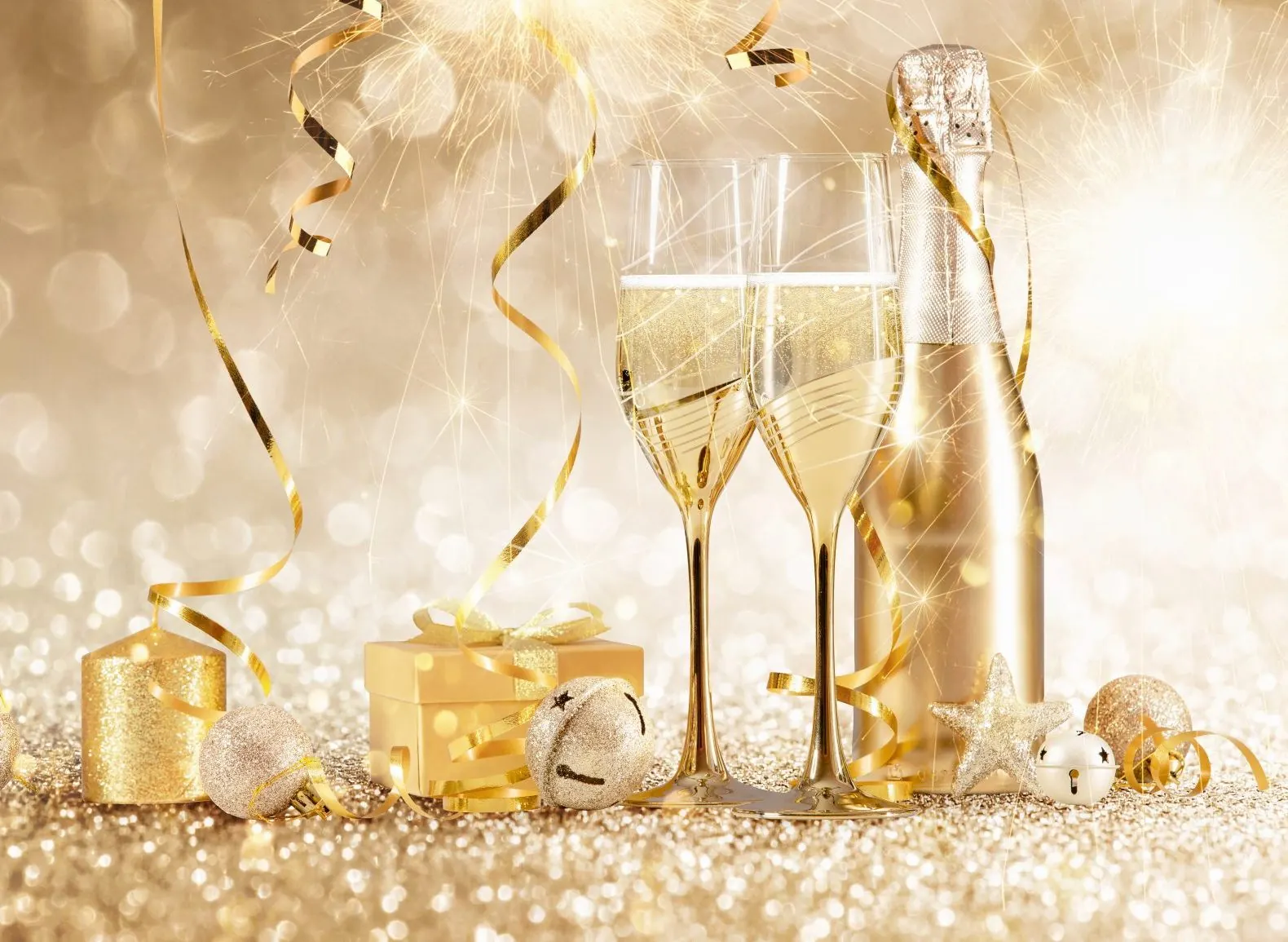 Sektgläser und Silvesterdekoration in Gold