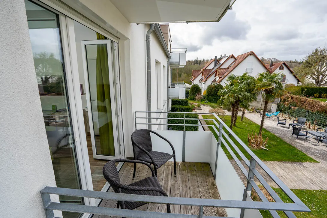Balkon mit Stuhl und Blick ins Grüne