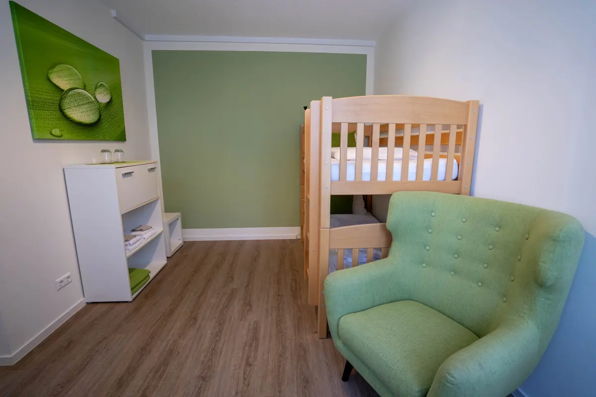 Kinderzimmer mit Babybett und Sessel